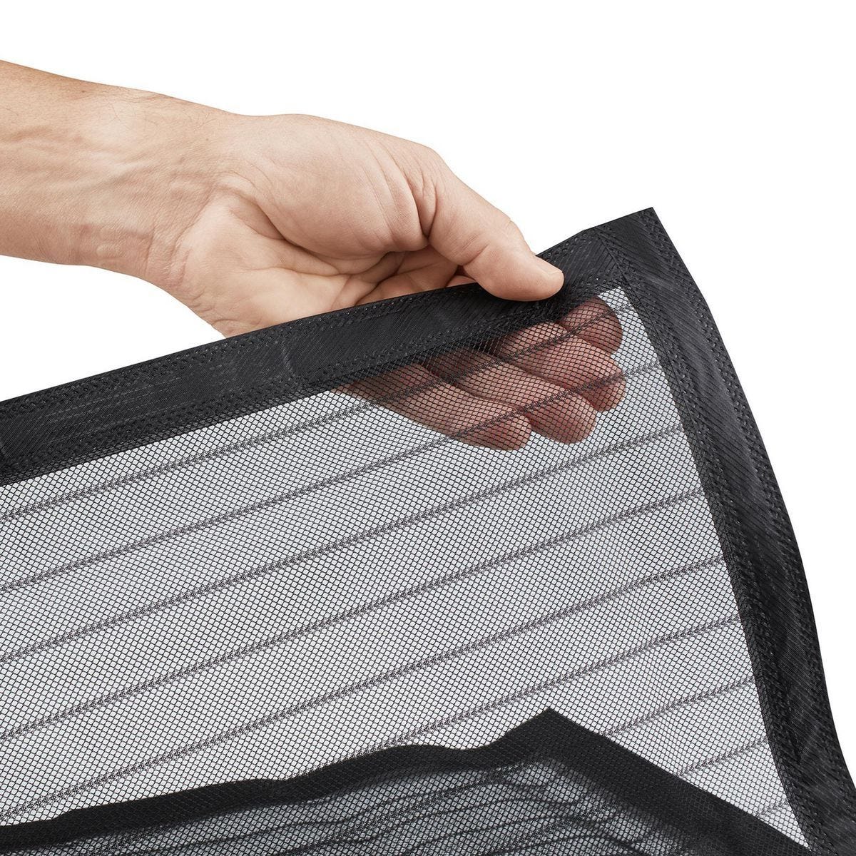 A close-up of a hand holding the corner of a black mesh screen or filter panel with a black stitched border, shown against a plain white background.