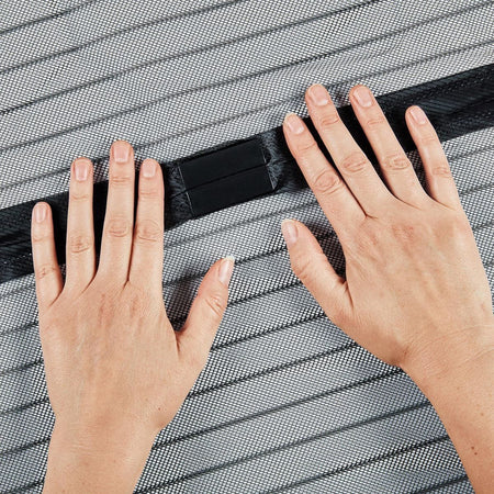 Hands holding a black strip against a textured gray surface