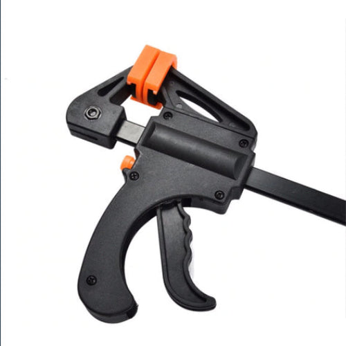 Black and orange clamping tool on a white background