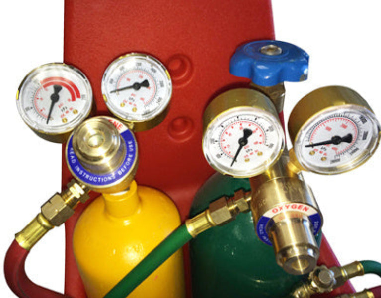 Oxygen and acetylene regulators with hoses on a white background