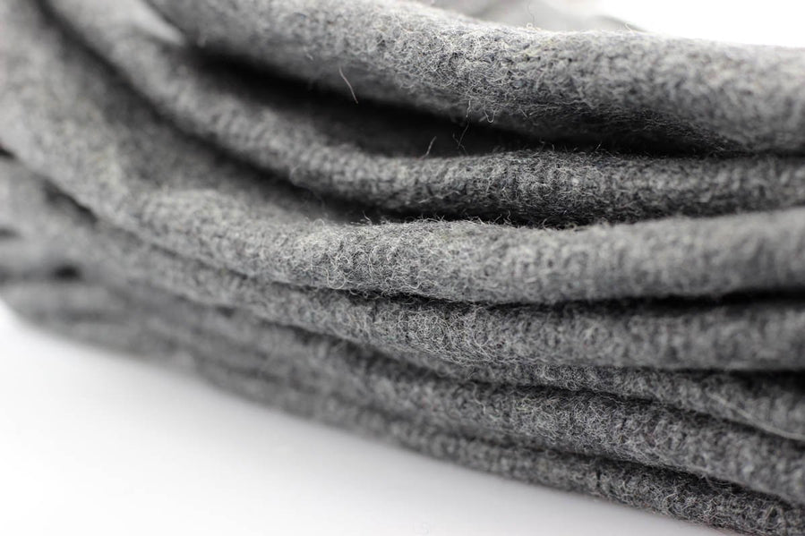 A close-up of folded gray felt fabric, showing its soft, textured surface on a white background.