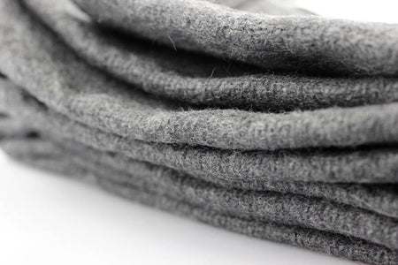 A close-up of folded gray felt fabric, showing its soft, textured surface on a white background.