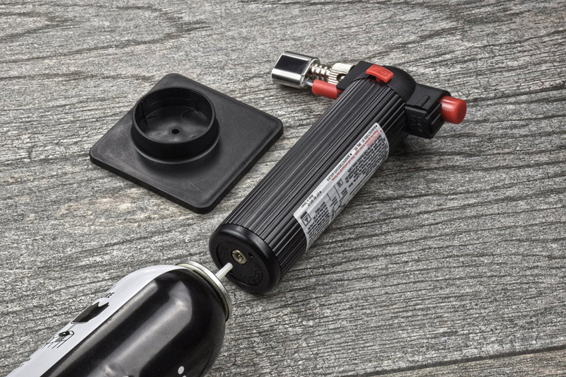 Butane lighter and gun on a wooden surface