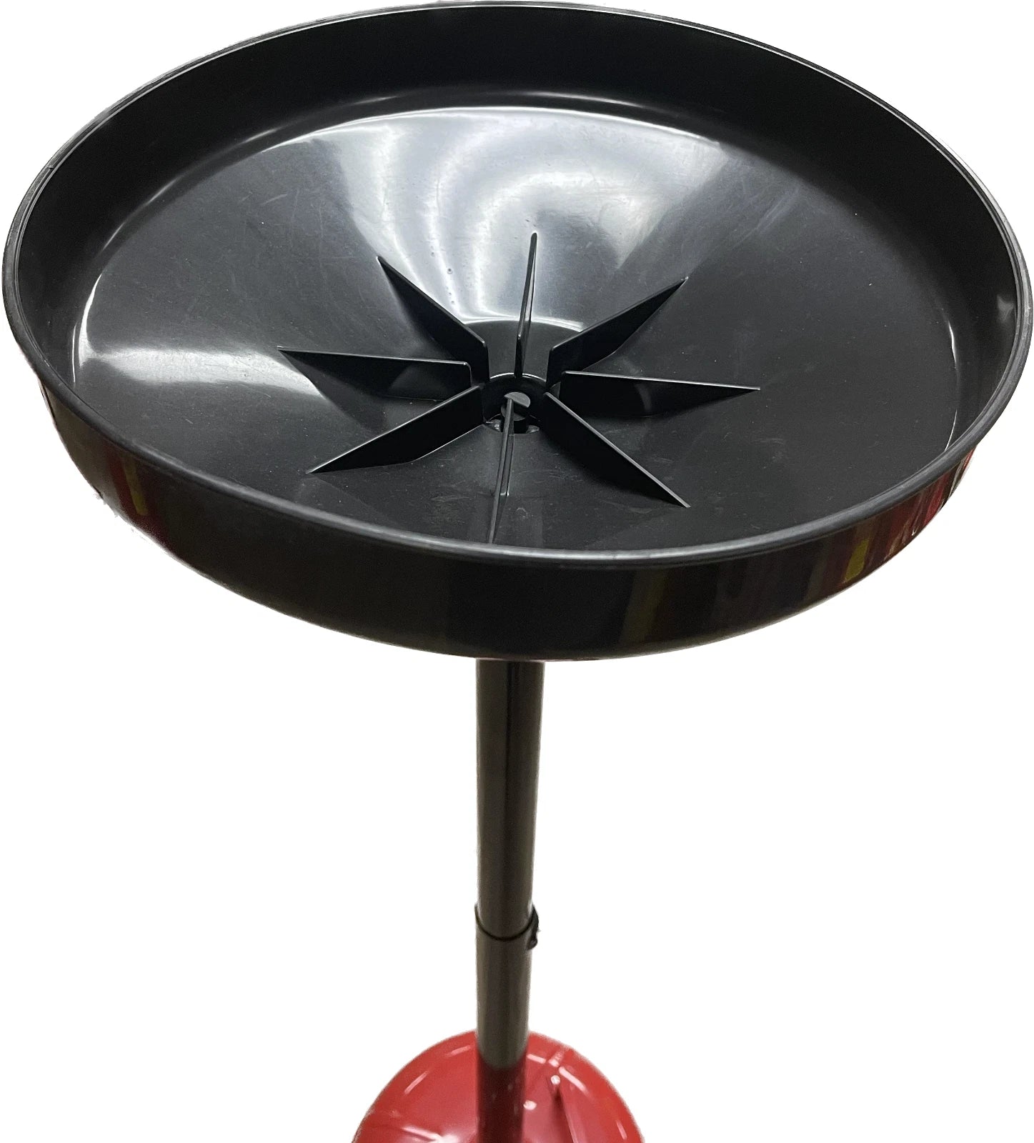 A black circular metal oil drain pan with a star-shaped drain opening, mounted on a black pole with a red base, shown against a plain white background.