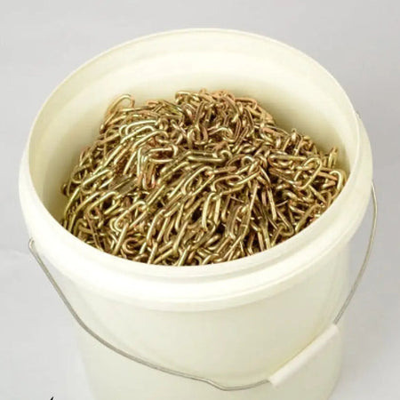 White bucket filled with gold chains on a white background